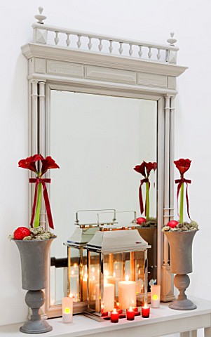 CHRISTMAS__TABLE_ON_LANDING_WITH_URNS__RED_AMARYLLIS_AND_RED_BAUBLES__MIRROR__STORM_LANTERN__CANDLES