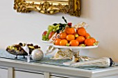 CLARE MATTHEWS CHRISTMAS HOUSE INTERIOR: DRESSER WITH OIL PAINTING  ORANGES  GRAPES AND NUTS IN BOWLS  SILVER BAUBLES