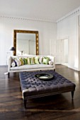 DESIGNER: JOHN MINSHAW - THE SITTING ROOM WITH WOODEN FLOOR  SETTEE  CUSHIONS AND MASSIVE MIRROR BESIDE THE WALL