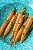 DESIGNER: CLARE MATTHEWS - CLOSE UP OF COOKED ORANGE CARROTS IN A BLUE BOWL. EDIBLE  VEGETABLE  FOOD