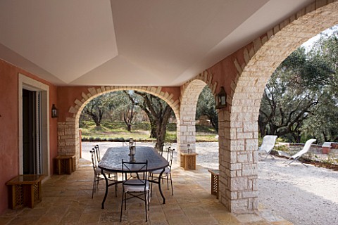 DESIGNER_GINA_PRICE__CORFU__VILLA_ONEIRO__LARGE_SHADED_DINING_AREA_WITH_TABLE_AND_LOUNGERS_BEYOND
