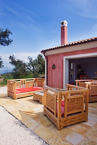 DESIGNER_GINA_PRICE__CORFU__VILLA_ONEIRO__OUTDOOR_PATIO_WITH_WOODEN_SEATS_AND_CUSHIONS_BESIDE_THE_VI