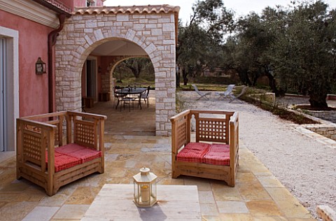 DESIGNER_GINA_PRICE__CORFU__VILLA_ONEIRO__OUTDOOR_PATIO_WITH_WOODEN_SEATS_AND_CUSHIONS_BESIDE_THE_VI