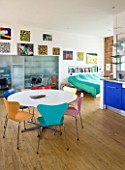 ROSE GRAY AND SCULPTOR DAVID MACILWAINE: DAVIDS ART STUDIO WITH COLOURED CHAIRS AND CANVASES ON WALLS
