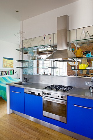 ROSE_GRAY_AND_SCULPTOR_DAVID_MACILWAINE_DAVIDS_ART_STUDIO_WITH_BLUE_KITCHEN_UNITS__AND_CANVASES_ON_W