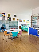 ROSE GRAY AND SCULPTOR DAVID MACILWAINE: DAVIDS ART STUDIO WITH BLUE KITCHEN UNITS  CANVASES ON WALLS  BED  TABLE WITH COLOURED CHAIRS