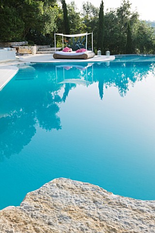 THE_ROU_ESTATE__CORFU_THE_SWIMMING_POOL_WITH_A_WICKER_SEAT_WITH_AWNING_AND_PINK_CUSHIONS