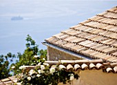 THE ROU ESTATE  CORFU: TILED ROOF WITH SEA AND SHIP BEYOND