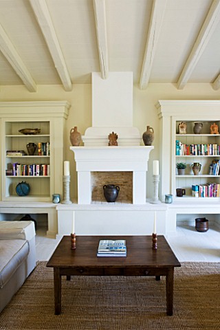 THE_ROU_ESTATE__CORFU_SITTINGLIVING_ROOM_WITH_RAISED_FIREPLACE_AND_BOOKSHELVES