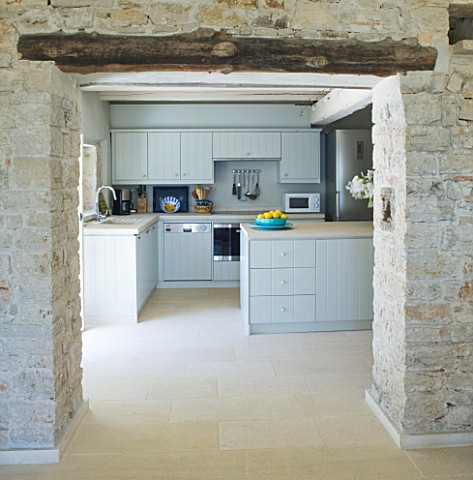 THE_ROU_ESTATE__CORFU_KITCHEN_WITH_STONE_WALLS_AND_BEAM_AND_LIMESTONE_TILED_FLOOR