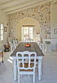 THE ROU ESTATE  CORFU: DINING AREA WITH TABLE AND CHAIRS AND STONE WALL