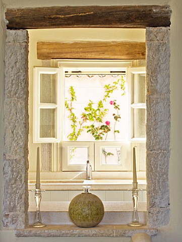THE_ROU_ESTATE__CORFU_VIEW_THROUGH_ALCOVE_TO_WINDOW_WITH_FLORAL_BLIND_AND_WOODEN_BEAMS