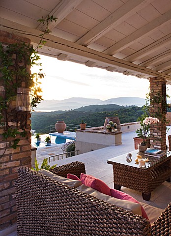 THE_KAPARELLI_ESTATE__CORFU__UNDERCOVER_PATIOSEATING_AREA_WITH_RATTAN_FURNITURE_AND_VIEW_OUT_TO_SWIM