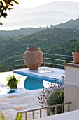 THE KAPARELLI ESTATE  CORFU - VIEW OVER SWIMMING POOL WITH TERRACOTTA URN AND ALBANIAN MOUNTAINS IN THE DISTANCE