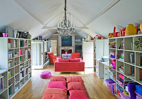PAULA_PRYKES_HOUSE__SUFFOLK_FAMILY_ROOM_WITH_BOOKSHELVES_AND_SOFA_IN_FRONT_OF_FIREPLACE