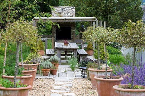 DESIGNER_CLARE_MATTHEWS__DEVON__OUTDOOR_KITCHEN_WITH_PIZZA_OVEN_AND_LARGE_DINING_TABLE
