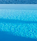 CORFU  GREECE: DESIGNER: DOMINIC SKINNER - MEDITTERANEAN STYLE GARDEN  - INFINITY POOL - DETAIL OF RIPPLING BLUE WATER AND VIEW OUT TO SEA