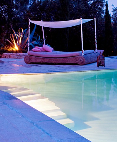 THE_ROU_ESTATE__CORFU__GREECE_DESIGNER_DOMINIC_SKINNER___A_PLACE_TO_SIT__THE_SWIMMING_POOL_AREA__LIT