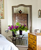 DESIGNER: ANNE FOWLER - MASTER BEDROOM WITH MIRROR AND VASE OF FLOWERS