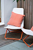 DESIGNERS WYNNIAT- HUSEY CLARKE: MODERN  CONTEMPORARY TOWN GARDEN IN BRIGHTON - A PLACE TO SIT - WHITE DECKCHAIRS ON DECKING WITH ORNAGE CUSHIONS