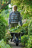 MOORS MEADOW GARDEN & NURSERY  HEREFORDSHIRE: ROS BISSELL WITH WHEELBARROW