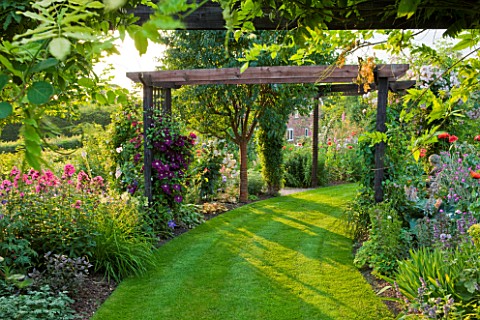 MEADOW_FARM__WORCESTERSHIRE_CURVED_LAWN_AND_PERGOLA_IN_SUMMER