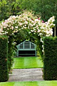 MEADOW FARM  WORCESTERSHIRE: A PLACE TO SIT - YEW HEDGES WITH LUTYENS BENCH BENEATH ROSE PHYLLIS BIDE TRAINED AS ARCH