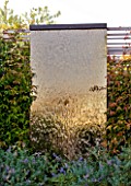 DESIGNER: CHARLOTTE ROWE  LONDON: ROOF GARDEN - BRONZE GLASS WATERWALL SURROUNDED BY CLIMBERS, WATERFALL, WATER, FALL, MODERN, CONTEMPORARY
