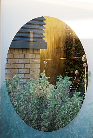 DESIGNER_CHARLOTTE_ROWE__LONDON_ROOF_GARDEN__GLASS_SCREEN_WITH_VIEW_PAST_ARTEMISIA_AND_ALLIUM_SPHAER