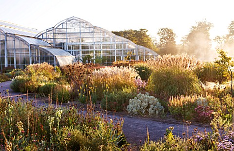 RHS_GARDEN__WISLEY__SURREY__THE_GLASSHOUSE_AT_DAWN_WITH_PERENNIAL_PLANTING_BY_TOM_STUART_SMITH
