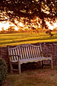 THE OLD RECTORY  HASELBECH  NORTHAMPTONSHIRE: EVENING SUNLIGHT ON WOODEN BENCH