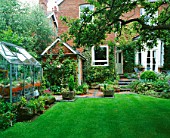 VIEW ACROSS LAWN TOWARDS THE HOUSE WITH GREENHOUSE ON LEFT.  DESIGNER: MALLEY TERRY