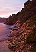 DOMAINE DU RAYOL  FRANCE: VIEW FROM THE BEACH HOUSE ACROSS THE ROCKS AND MEDITERRANEAN SEA AT DUSK - SUNSET