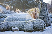 PETTIFERS  OXFORDSHIRE: GARDEN IN SNOW IN WINTER - THE PARTERRE IN WINTER WITH CLIPPED BOX AND YEW. SCULPTURE IN STONE BY BRIONY LAWSON