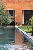 DESIGNERS ERIC OSSART AND ARNAUD MAURIERES  MOROCCO: AL HOSSOUN - COURTYARD SURROUNDING RECTANGULAR POOL WITH BUILDINGS AND LAWN