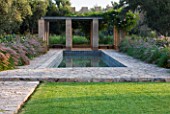 DESIGNERS ERIC OSSART AND ARNAUD MAURIERES  MOROCCO: DAR IGDAD - SWIMMING POOL AND RAMMED EARTH PERGOLA WITH BORDER OF PENNISETUM SETACEUM