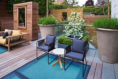 MODERN_ROOF_GARDEN_BY_STEPHEN_WOODHAMS_LONDON_TERRACESEATING_AREA_WITH_WOODEN_BENCH_CHAIRS_LAVENDER_