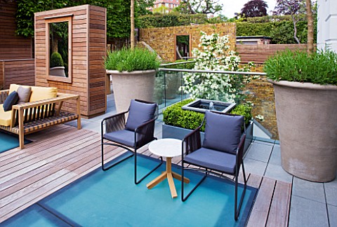 MODERN_ROOF_GARDEN_BY_STEPHEN_WOODHAMS_LONDON_TERRACESEATING_AREA_WITH_WOODEN_BENCH_CHAIRS_LAVENDER_