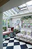 DESIGNER BUTTER WAKEFIELD  LONDON: CONSERVATORY WITH SHELVES DISPLAYING PLATES AND SETTEE