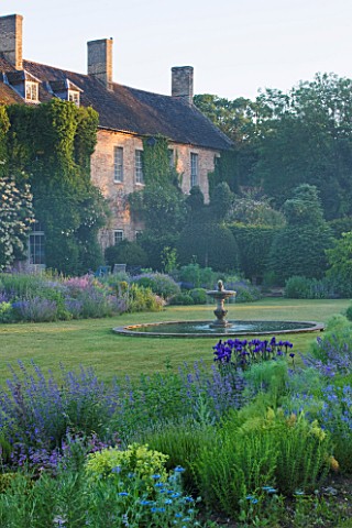 NARBOROUGH_HALL__NORFOLK_DAWN_LIGHT_ON_THE_HALL_SEEN_FROM_THE_BLUE_GARDEN_WITH_THE_FOUNTAIN_IN_THE_C