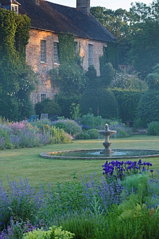 NARBOROUGH_HALL__NORFOLK_DAWN_LIGHT_ON_THE_HALL_SEEN_FROM_THE_BLUE_GARDEN_WITH_THE_FOUNTAIN_IN_THE_C
