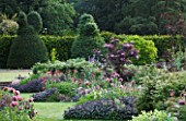 NARBOROUGH HALL  NORFOLK: THE PLUM AND CHOCOLATE GARDEN WITH TOPIARY  POPPIES AND SAGE