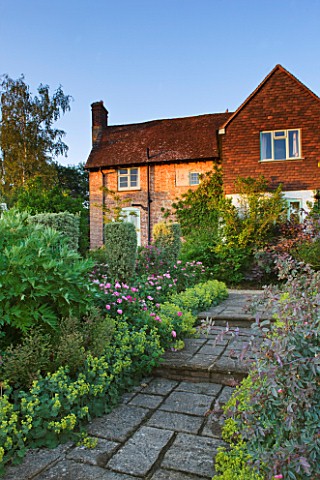 SANDHILL_FARM_HOUSE__HAMPSHIRE__DESIGNER_ROSEMARY_ALEXANDER_VIEW_TO_THE_HOUSE_ALONG_A_PATH_EDGED_WIT