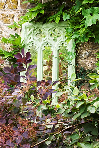 SANDHILL_FARM_HOUSE__HAMPSHIRE__DESIGNER_ROSEMARY_ALEXANDER__MIRROR_ON_WALL_IN_FRONT_GARDEN_WITH_COT