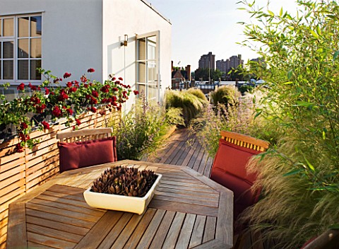 LONDON_ROOFTOP_GARDEN_WOODEN_TABLE_AND_CHAIRS_ON_WOODEN_DECKING_SURROUNDED_BY_STIPA_TENUISSIMA_AND_P