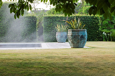 PRIVATE_GARDEN_COTSWOLDS_DESIGNER_ALISON_HENRY__LAWN_SWIMMING_POOL_BRONZE_CONTAINERS_WITH_CORDYLINE_