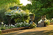 DESIGNER ALISON HENRY - PRIVATE GARDEN, COTSWOLDS: LAWN AND WALL WITH STONE URNS / CONTAINERS WITH HEBE - WHITE ICEBERG ROSES AND PERGOLA - ENGLISH GARDEN, CLASSIC, COUNTRY