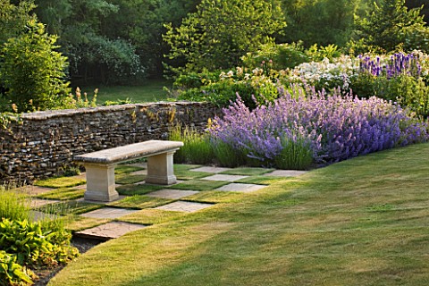 DESIGNER_ALISON_HENRY__PRIVATE_GARDEN_COTSWOLDS_STONE_SEAT__BENCH_BY_STONE_WALL_WITH_CHEQUERBOARD_GR
