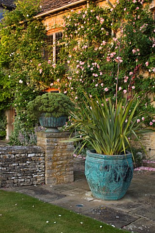 DESIGNER_ALISON_HENRY_PRIVATE_GARDEN_COTSWOLDS__STONE_TERRACE__PATIO_BESIDE_THE_HOUSE_WITH_BRONZE_CO