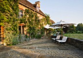 DESIGNER ALISON HENRY, PRIVATE GARDEN, COTSWOLDS - LAWN, STONE TERRACE / PATIO WITH SEATS AND CANVAS SAIL CANOPY - COUNTRY, GARDEN, SUMMER, CLASSIC, ENGLISH